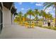 Resort style pool area with yellow accent furniture, tables, and umbrellas, surrounded by lush tropical landscaping at 6109 Marsh Trail Dr, Odessa, FL 33556