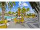 Poolside view showcasing yellow accent furniture, palm trees, cabana and luxurious lounging arrangements at 6109 Marsh Trail Dr, Odessa, FL 33556