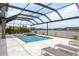 Backyard swimming pool and hot tub with lounge chairs under a screened enclosure near the lake at 6109 Marsh Trail Dr, Odessa, FL 33556