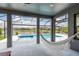 A hammock hangs near the enclosed backyard pool and spa area, near a scenic lake at 6109 Marsh Trail Dr, Odessa, FL 33556