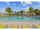 Serene pool area with palm trees and yellow lounge chairs for relaxing by the water at 6109 Marsh Trail Dr, Odessa, FL 33556