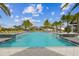 Community pool with lush landscaping, palm trees, lounge chairs and other yellow accent furniture at 6109 Marsh Trail Dr, Odessa, FL 33556