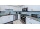 Modern kitchen featuring white cabinets, stainless steel appliances, granite countertops and bright lighting at 6145 Sun Blvd # 404, St Petersburg, FL 33715
