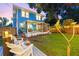 Serene backyard featuring a screened porch, lush lawn, mature trees, and stylish seating areas, perfect for outdoor living at 661 14Th S Ave, St Petersburg, FL 33701