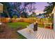 Charming backyard featuring a cozy deck, ambient string lighting, and mature landscaping for a tranquil outdoor experience at 661 14Th S Ave, St Petersburg, FL 33701