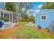 Backyard view showcasing a screened patio, a storage shed, and well-maintained landscaping at 661 14Th S Ave, St Petersburg, FL 33701