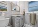 Bathroom featuring gray vanity, granite countertop, decorative floor tiles, and framed mirror at 661 14Th S Ave, St Petersburg, FL 33701
