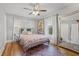 Cozy bedroom with hardwood floors, ceiling fan, and large mirror reflecting natural light at 661 14Th S Ave, St Petersburg, FL 33701