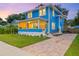 Charming blue home with a well-manicured lawn, beautiful landscaping, and a brick driveway at 661 14Th S Ave, St Petersburg, FL 33701
