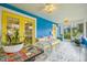Charming screened front porch with tile floor features seating, table, and yellow french doors at 661 14Th S Ave, St Petersburg, FL 33701