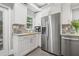 This bright white kitchen has granite counters, stainless steel appliances, and white cabinets at 661 14Th S Ave, St Petersburg, FL 33701
