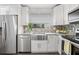 This bright white kitchen has granite counters, a farmhouse sink and stainless steel appliances at 661 14Th S Ave, St Petersburg, FL 33701