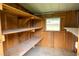 Spacious shed interior with built-in shelving provides ample storage solutions with natural light from the window at 7240 Ottley St, Zephyrhills, FL 33541
