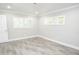 A bedroom with gray wood-look tile flooring features white trim and window shutters at 913 Spindle Palm Way, Apollo Beach, FL 33572