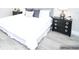 Bedroom with white bedding, gray pillows and black nightstand at 913 Spindle Palm Way, Apollo Beach, FL 33572