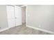 A bedroom features gray wood-look tile flooring, an open door and large closet at 913 Spindle Palm Way, Apollo Beach, FL 33572