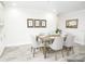 Bright dining room with wood look tile flooring and space for six at the table at 913 Spindle Palm Way, Apollo Beach, FL 33572