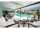 Covered outdoor patio with views of the pool, canal and comfortable seating arrangement at 913 Spindle Palm Way, Apollo Beach, FL 33572
