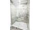 Walk-in shower with glass door and marble style tiles at 913 Spindle Palm Way, Apollo Beach, FL 33572