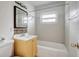 Bathroom features a tiled tub, yellow vanity with mosaic backsplash, and large mirror at 963 27Th S Ave, St Petersburg, FL 33705