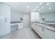 Bright bathroom with a double sink vanity, marble tile flooring, makeup area, and a separate toilet room at 1 Seaside Ln # 302, Belleair, FL 33756
