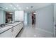 Modern bathroom showcasing a double vanity, large mirror, marble tile flooring, and access to closets at 1 Seaside Ln # 302, Belleair, FL 33756