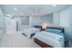 Bright bedroom featuring two beds, a ceiling fan, and a view into the ensuite bathroom at 1 Seaside Ln # 302, Belleair, FL 33756