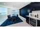 Bright dining room featuring a modern light fixture, ocean views, and a sleek bar area with a wine cooler at 1 Seaside Ln # 302, Belleair, FL 33756