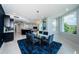 Open-concept dining area with a stylish glass table, modern lighting, and access to balcony with lovely views at 1 Seaside Ln # 302, Belleair, FL 33756