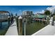 Private boat dock with boat lift and waterfront condo in the background at 1 Seaside Ln # 302, Belleair, FL 33756