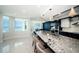 A modern kitchen boasting granite countertops, stainless steel appliances, and serene views of the ocean at 1 Seaside Ln # 302, Belleair, FL 33756
