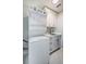 Well-lit laundry room featuring stackable washer and dryer and custom white cabinets at 1 Seaside Ln # 302, Belleair, FL 33756