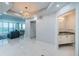Bright living room with pendant lighting, marble flooring, and access to bath with sink and vanity at 1 Seaside Ln # 302, Belleair, FL 33756
