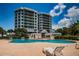 Stunning pool with lounge chairs and the condo building in the background is perfect for enjoying your time outdoors at 1 Seaside Ln # 302, Belleair, FL 33756