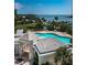 Aerial view of the community pool, adjacent building, boat docks, and lush landscaping at 1 Seaside Ln # 302, Belleair, FL 33756