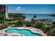Community pool with bay view surrounded by mature landscaping at 1 Seaside Ln # 302, Belleair, FL 33756
