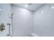 The shower features white marble tiling, a rainfall showerhead, and an adjustable handheld shower at 1 Seaside Ln # 302, Belleair, FL 33756