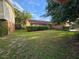 A single-story home with a green lawn and mature trees offering shade and curb appeal at 1011 Mallow Way, Brandon, FL 33510