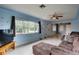 Spacious living room featuring large windows, ceiling fan, and comfortable seating at 10703 59Th Ave, Seminole, FL 33772