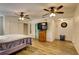 This cozy bedroom features a ceiling fan, hardwood floors, natural light, closet space, and a tv for entertainment at 10703 59Th Ave, Seminole, FL 33772