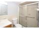 Bright bathroom with a white vanity, toilet and a glass-enclosed shower at 10740 Oldham Rd, Port Richey, FL 34668