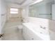 Bright bathroom featuring a tub with shower, accessible grab bars, and tiled vanity at 10740 Oldham Rd, Port Richey, FL 34668