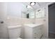 Neutral bathroom with tiled wall, vanity with mirror, and a toilet at 10740 Oldham Rd, Port Richey, FL 34668