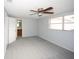 A bright bedroom with carpet, a ceiling fan, and an ensuite bathroom at 10740 Oldham Rd, Port Richey, FL 34668