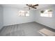 This bedroom features neutral colored walls, carpet and a ceiling fan at 10740 Oldham Rd, Port Richey, FL 34668