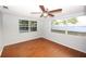 A spacious bedroom with a ceiling fan, laminate wood floors, and bright natural light at 10740 Oldham Rd, Port Richey, FL 34668