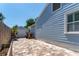 Paver patio in backyard with view of blue house and detached garage at 115 S Beverly Ave, Tampa, FL 33609