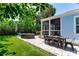 Backyard with outdoor dining and lounge area with a screened in porch and small yard at 115 S Beverly Ave, Tampa, FL 33609