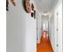 Hallway showcasing hardwood floors, white walls, and decorative masks, enhancing the home's character at 115 S Beverly Ave, Tampa, FL 33609
