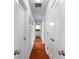Hallway with hardwood floors and white doors, leading to various rooms in the home at 115 S Beverly Ave, Tampa, FL 33609